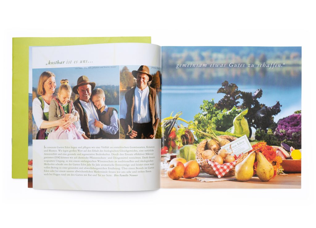 Aufgeschlagenes Heft zu Garten Eden mit Familienfotos und Gemüsestillleben am See für kostbar